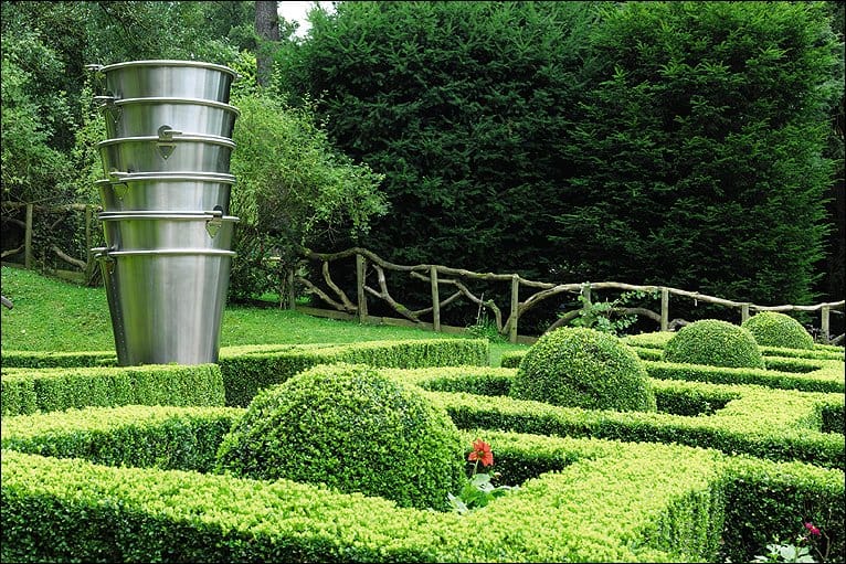 Ein Labyrinth aus Hecken mit einer großen Topfpflanze in der Mitte.