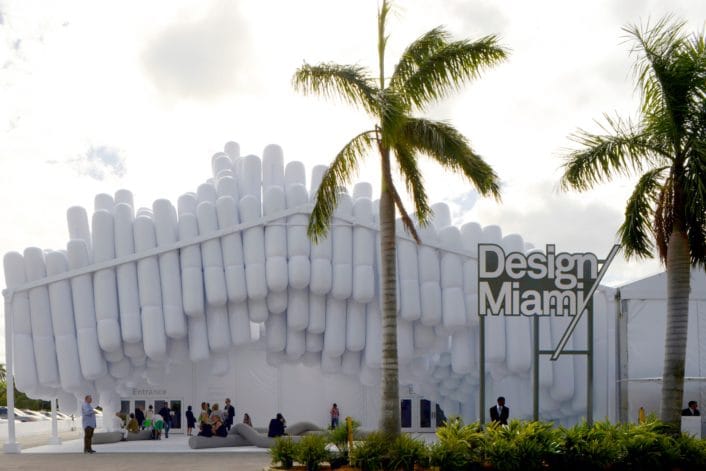 Weisses Gebäude der Design Miami mit Palmen davor.