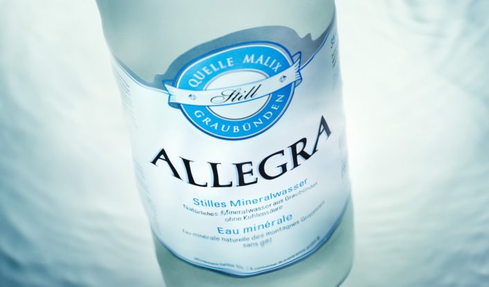 Eine Flasche Allegra auf blauem Hintergrund.