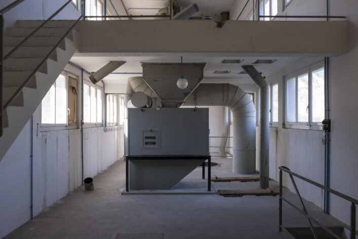 Ein Raum mit Treppe und einer Maschine im Industrieareal in Uri